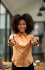 Portrait of black woman showing thumbs up and smiling in approval, agree everything excellent. Show...