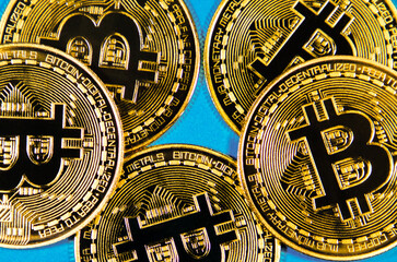 Golden Bitcoins cryptocurrency on a blue background. A virtual money