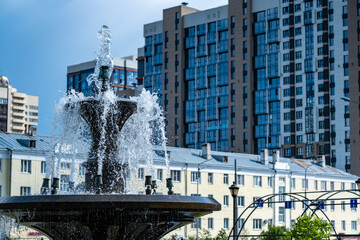 Fountain with streams of clear water on the background of the house.