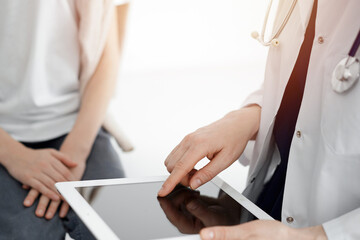 Doctor and child patient. The doctor is using tablet computer and is ready to examine the boy. The concept of ideal health in medicine