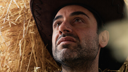 Pensive cowboy on hay. Close up