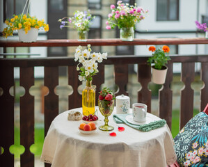 Morning tea with flowers and fruits on the terrace of a country house.