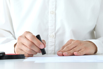 書類に押印をする人物の手元