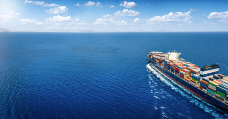 Aerial view of a large cargo ship carrying containers for import and export, business logistic and transportation in open sea with copy space  - obrazy, fototapety, plakaty