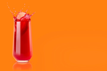 Cherry fresh red juice in glass with reflection, drops and splashind on orange background, copy space. Vitamin organic summer drink with splashes, drops and motion in glass.