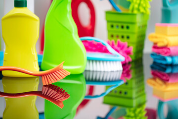 Office and house cleaning theme. Set of colorful cleaning products on shining table.