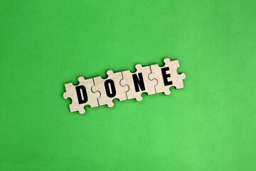 wooden puzzle with the word done. the concept of solving. the concept of completing or being...