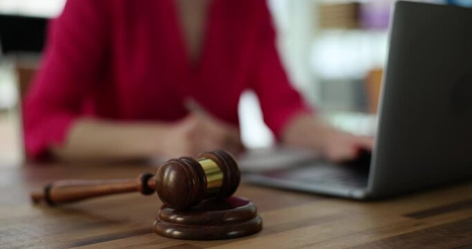 Person works on laptop and court gavel on table. Online auction or online crimes