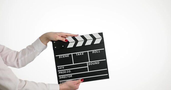 Woman holds movie clapperboard during film production shoot on white background. Start of filming series