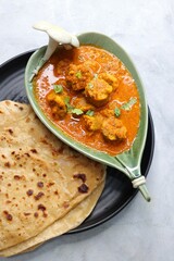 Rajasthani Gatta Curry or Besan Ke Gatte Ki Sabzi. Gatte are gram flour roundels or chickpea flour dumplings are cooked in a spicy, tangy yogurt based curry. delicacy of Rajasthan, India. copy space.