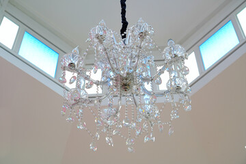 A beautiful chandelier is installed in the center of the atrium with a skylight above.