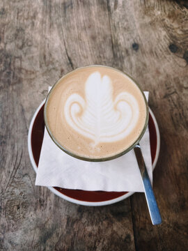 Glass of Caramel Latte with latte art with Wooden Background