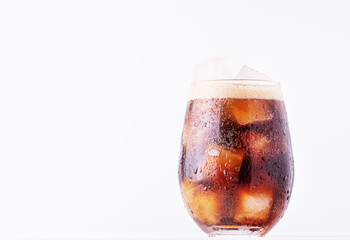 Brown soda, cold tea or coffee with ice cubes. Fresh cold sweet drink with ice cubes on white...
