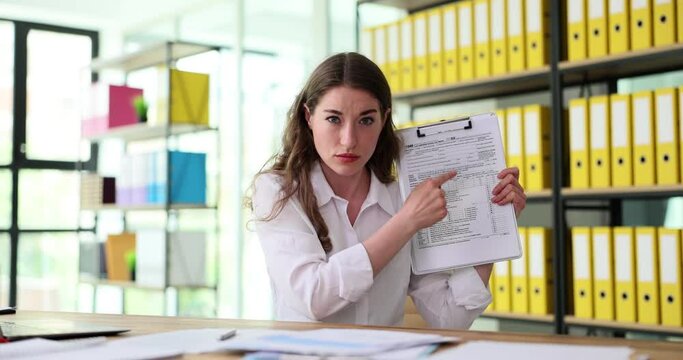 Business woman pointing at tax form 1040 in office. Time and control of the tax return