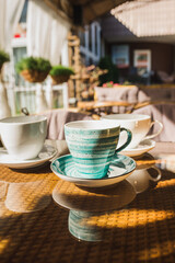 Cups of coffee and tea are on a glass table in the gazebo. Served for tea. table on the summer terrace of the cafe. morning ritual before work day. Rest between work and coffee break