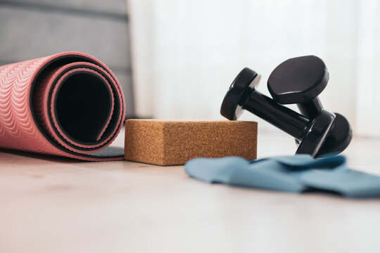Dumbbells and mat with yoga block on floor