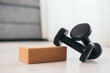 Dumbbells and yoga block on floor