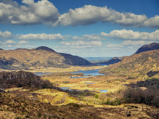 Fototapeta premium Stunning nature scene with mountains and cloudy sky in county Kerry, Ireland. Warm sunny day. Travel and sightseeing amazing Irish landscape. Popular tourist area with unique scenery.