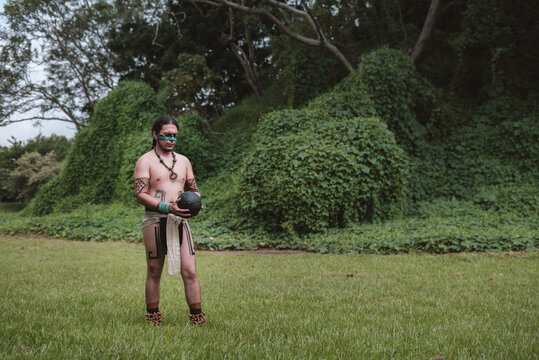 Characterized man walking on the grass holding a rubber ball