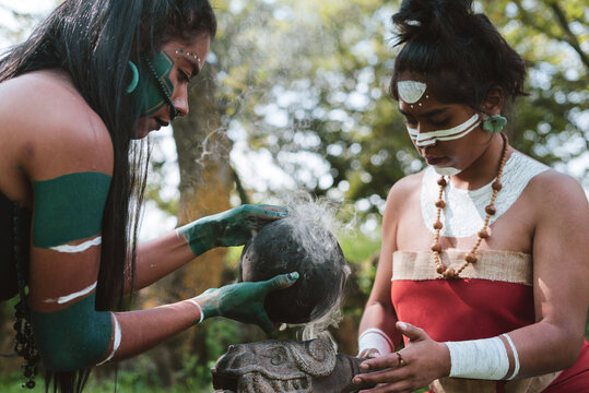 Mayan women with traditional garments performing smoke ritual with rubber ball