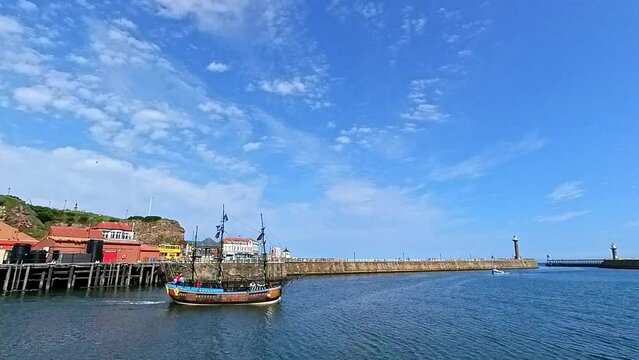 Sailing ship coming in to port in Whitby Harbour on the North Yorkshire Coast. Captured on a bright and sunny summer day