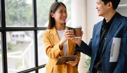 Two business worker standing and holding a coffee cup in modern office, successful, celebration, new project, team office concept