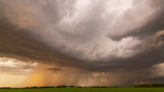 Rain curtains accompany a summertime thunderstorm as it dumps precipitation on Minnesota fields.