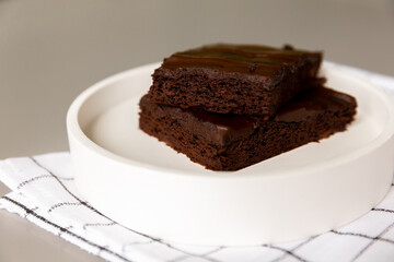 Chocolate brownies laid out on a plate, ready to serve. Healthy banana and cocoa dessert. Health and weight care