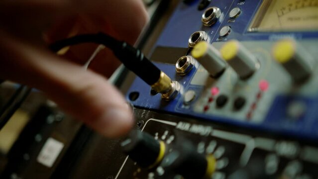 sound engineer connects Audio cable Professional wires with connectors to music equipment recording studio