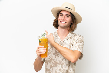 Young handsome man holding a cocktail isolated on white background pointing back