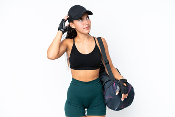 Young sport woman with sport bag isolated on white background having doubts and with confuse face expression