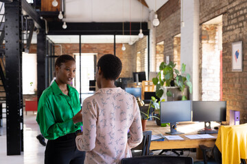 Busy african american female colleagues discussing work in creative office