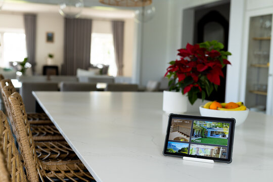 Tablet with a home security camera views on screen in kitchen