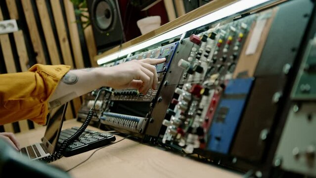 sound engineer works in music studio with monitors and equalizer mixing and mastering tracks recording song microphone on table