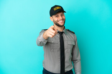 Young security man isolated on blue background points finger at you with a confident expression