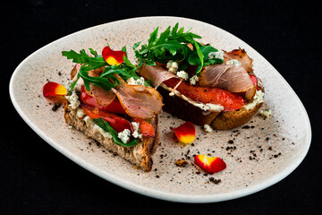 Bruschettas with bacon, sweet pepper, blue cheese and arugula, snack.