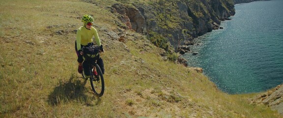 The beautiful woman is ride on top of a hill with the sea in the background, near the canyon. The...