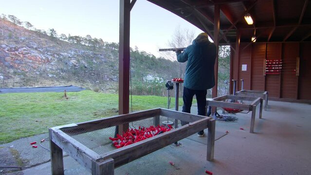 Skeet shooting man hitting target, wide.