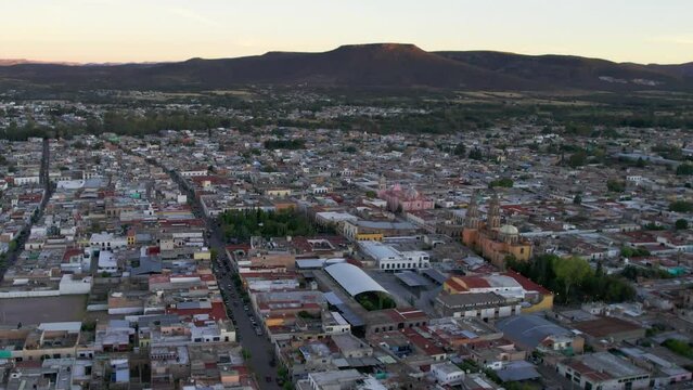 Drone moving towards the center of Jerez, Zacatecas, showcasing Rafael Paez garden, the parish, and the sanctuary in the distance.