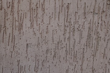 Close view of dusty brown wall with stucco worm finish