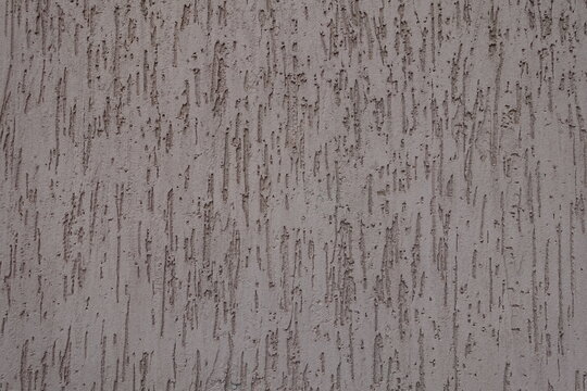 Surface of dusty brown wall with stucco worm finish