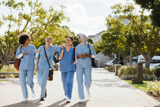 Fun in med school: Female health students laugh together as they walk to class