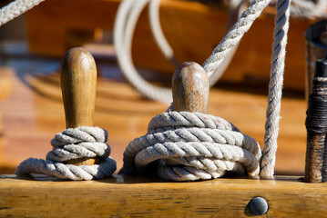Detail of mooring ropes and bollards on a wooden sailing ship.