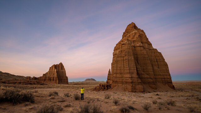 Rear view of a woman taking a photo of Temple of the Sun and Moon at sunset, Capitol Reef National Park, Wayne County, Utah, USA