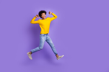 Fototapeta na wymiar Full body size cadre of young man jumping directing fingers himself best football player achievement isolated on violet color background
