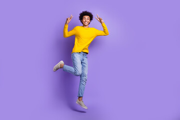 Fototapeta na wymiar Full body photo of jump young man have fun show double v-sign symbol hello greetings wear jeans shirt isolated on purple color background