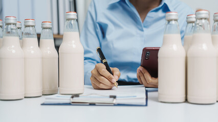Expert control quality milk factory worker checking milk bottle quality control procedure, Dairy factory industry products. Purchasing Department