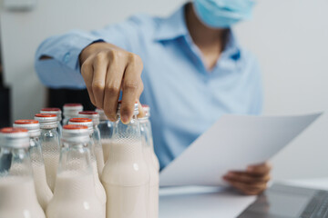 Expert control quality milk factory worker checking milk bottle quality control procedure, Dairy...