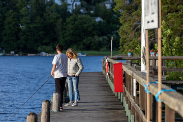 Stockholm, Sweden  A woman and a teenage nephew fishing on a dock on Lake Malaren.