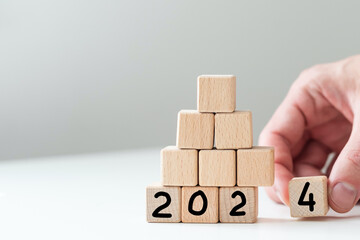 2024 Happy New Year eve wooden blocks flip change hand blue background. Countdown starting ending...